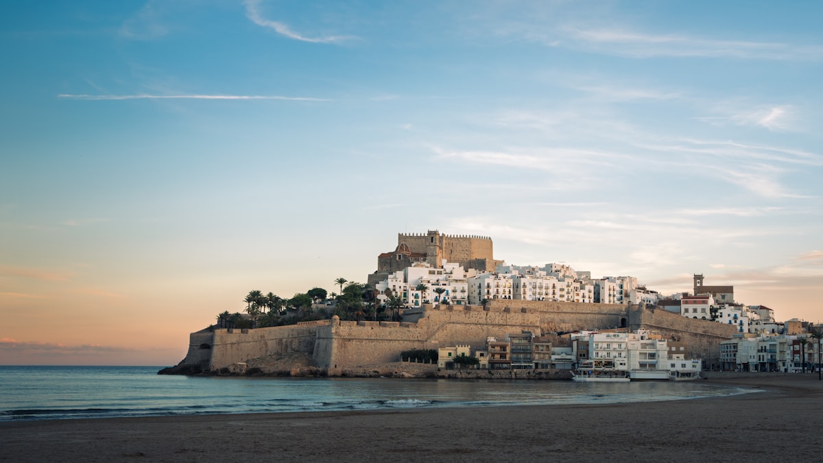 El casco antiguo amurallado y el castillo de Peñíscola sobre la playa al atardecer